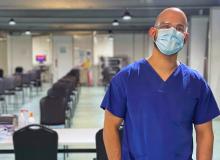Danny posing in his scrubs with mask and protective eyewear