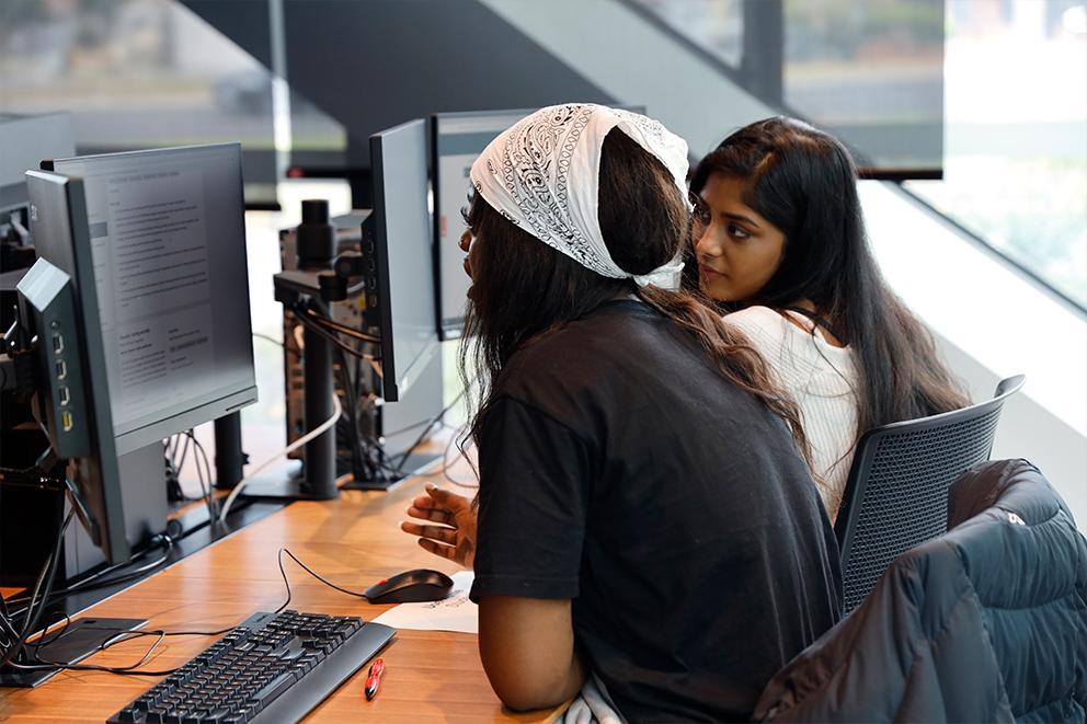 Two young women working at computers.
